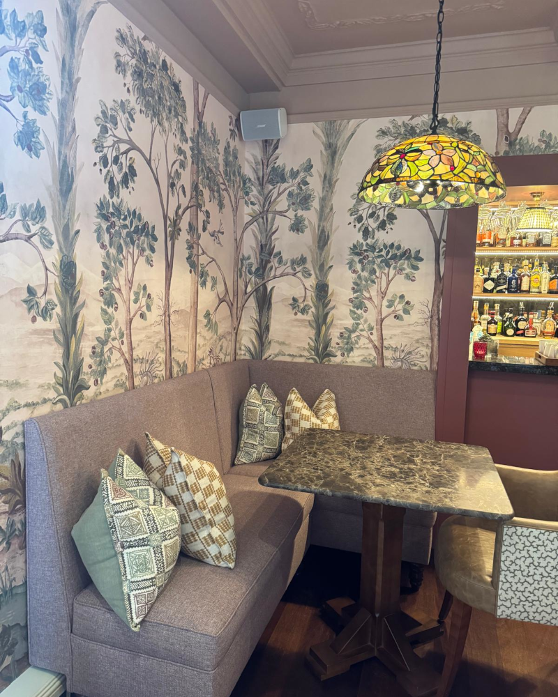 A lilac banquette with piped seat and narrow high-back.